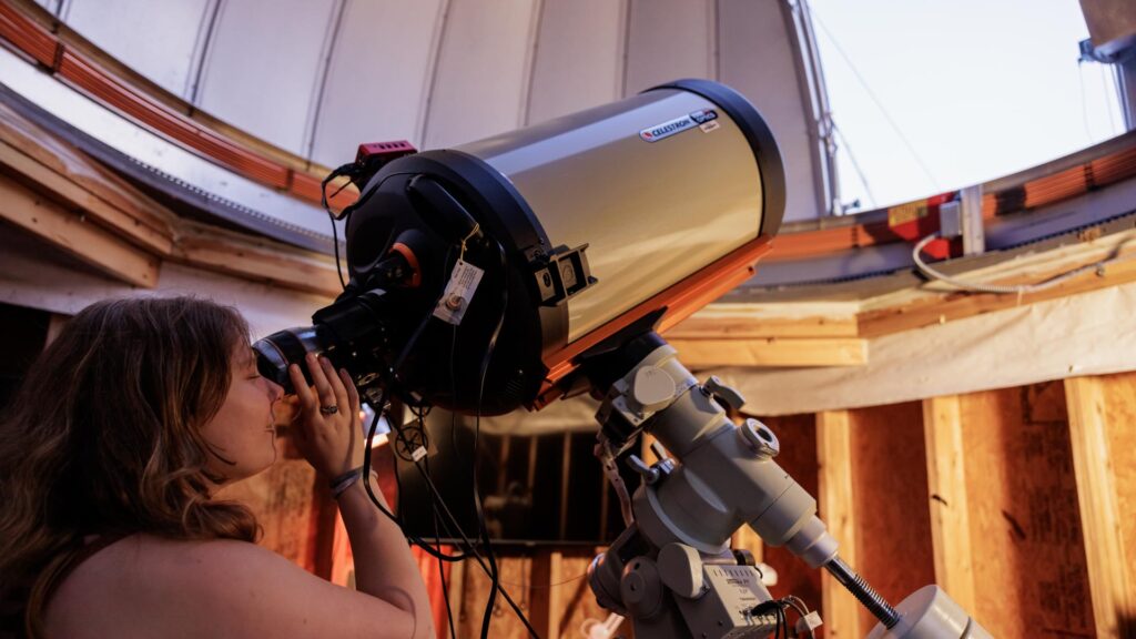 student looking through a telescope at tyson