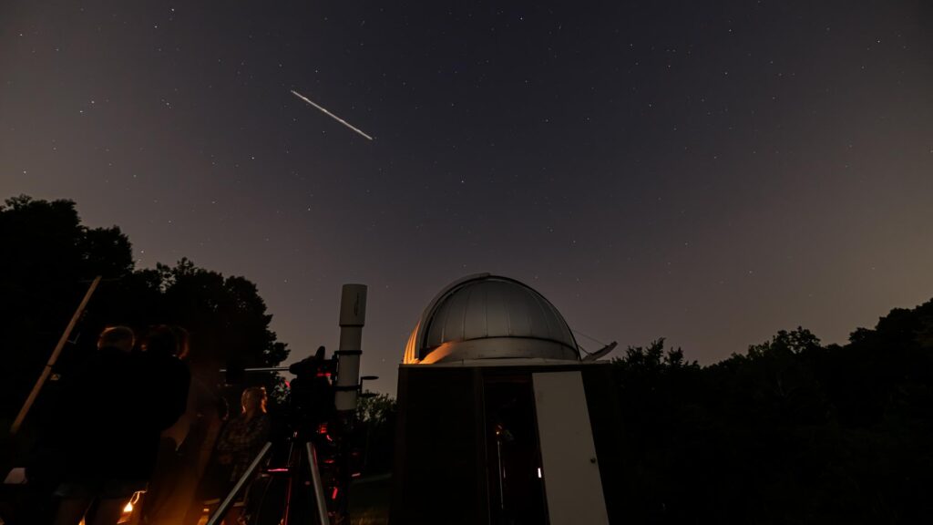 observatory at Tyson during night time with a shooting star in the top left